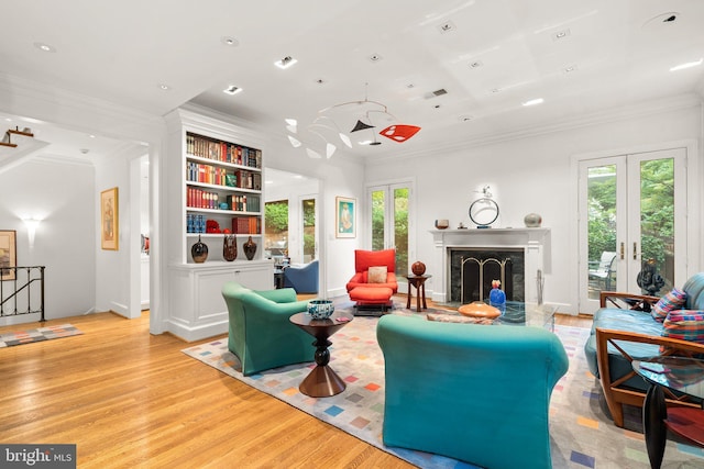 living room featuring a premium fireplace, crown molding, light hardwood / wood-style floors, and french doors