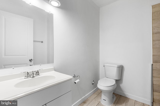 bathroom with wood-type flooring, toilet, and vanity