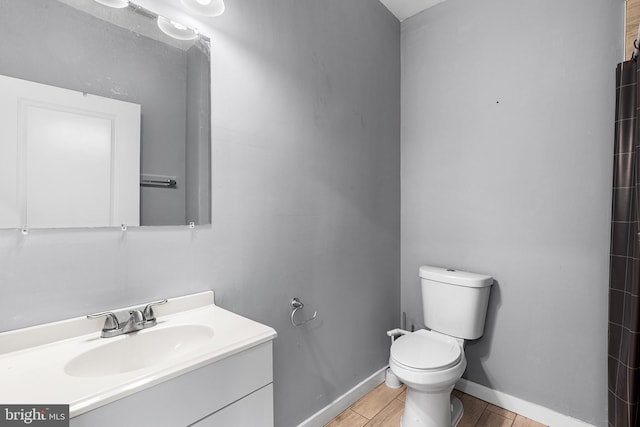 bathroom with toilet, wood-type flooring, and vanity