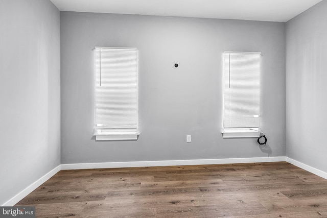 spare room with wood-type flooring and plenty of natural light