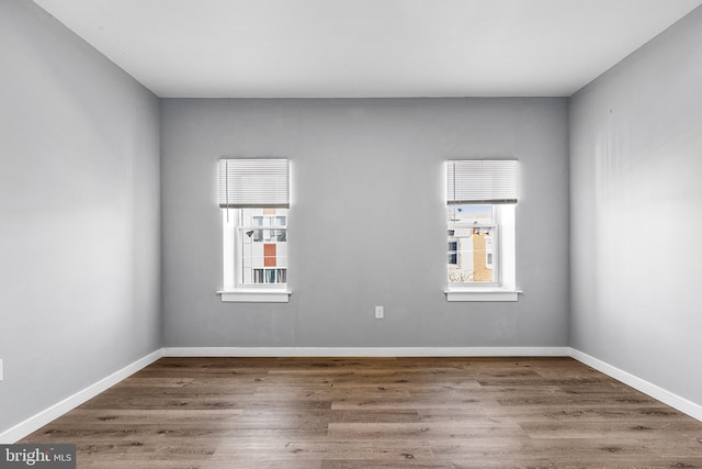 unfurnished room featuring a wealth of natural light and dark hardwood / wood-style flooring