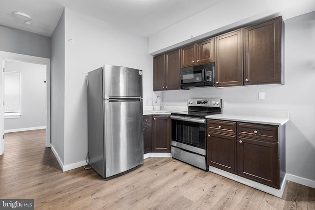 kitchen featuring stainless steel appliances, dark brown cabinets, and sink