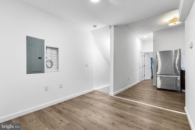 spare room featuring electric panel and hardwood / wood-style flooring