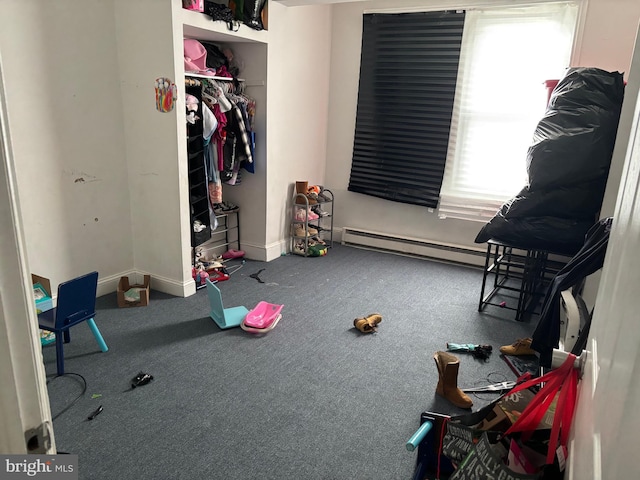 carpeted bedroom featuring multiple windows, a closet, and baseboard heating