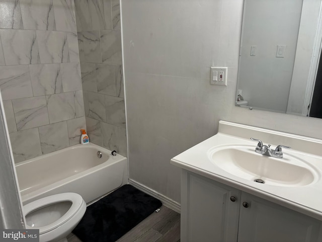 full bathroom featuring vanity, tiled shower / bath combo, wood-type flooring, and toilet