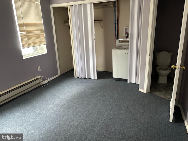 unfurnished bedroom with ensuite bathroom, washer / dryer, dark colored carpet, a walk in closet, and a closet