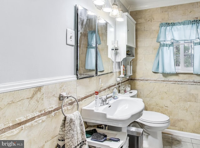 bathroom with toilet, tile walls, tile patterned flooring, and sink