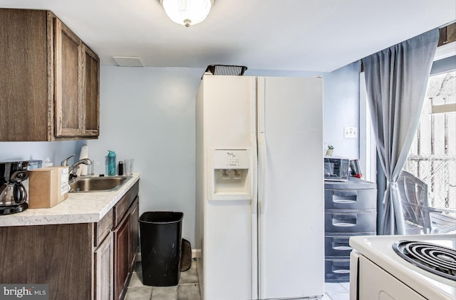 kitchen with sink, white appliances, and light tile patterned flooring