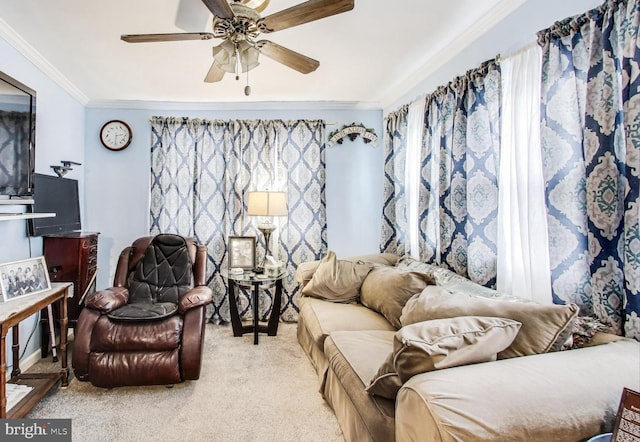 living room with ceiling fan, crown molding, and light colored carpet