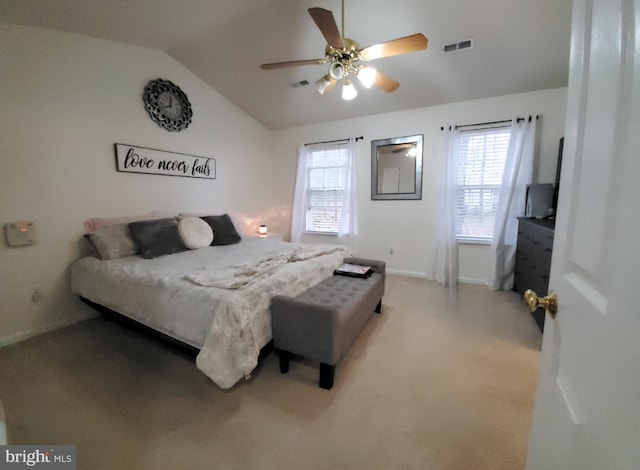 bedroom with vaulted ceiling, ceiling fan, carpet, and multiple windows