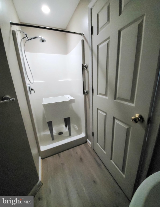 bathroom with a shower and hardwood / wood-style flooring