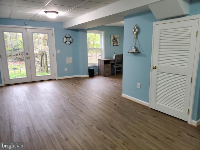 spare room with a paneled ceiling, french doors, and wood-type flooring