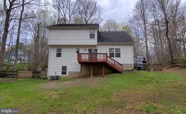 back of house featuring central AC unit, a deck, and a yard