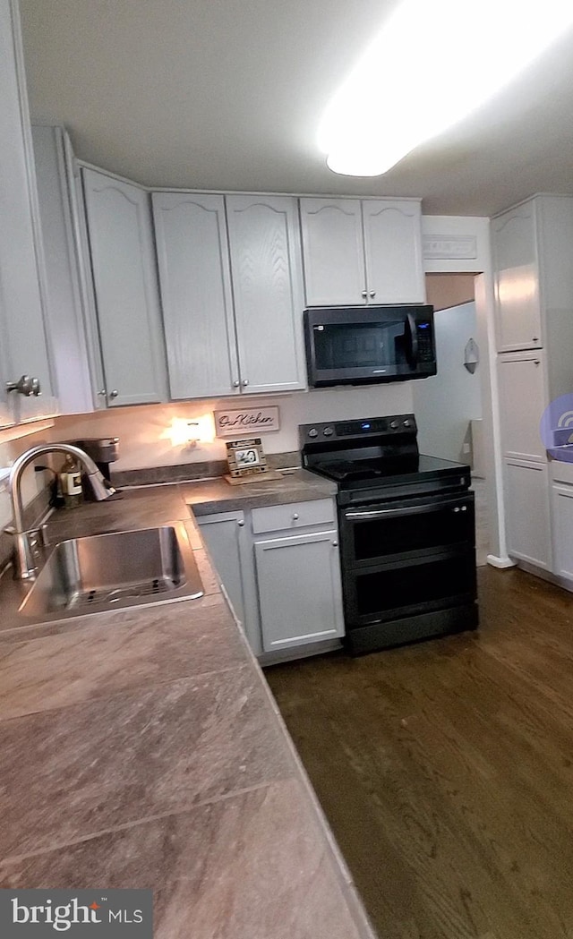 kitchen with double oven range, white cabinetry, dark hardwood / wood-style floors, and sink