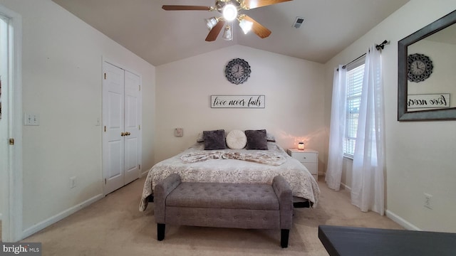 carpeted bedroom with ceiling fan, a closet, and lofted ceiling