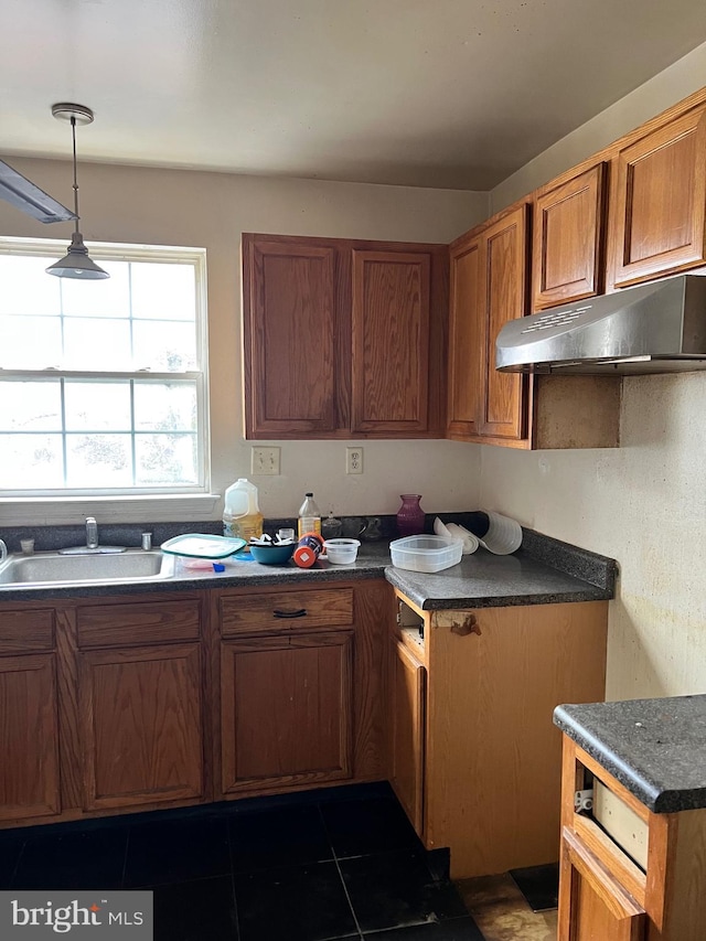 kitchen featuring sink, dark tile patterned flooring, and hanging light fixtures