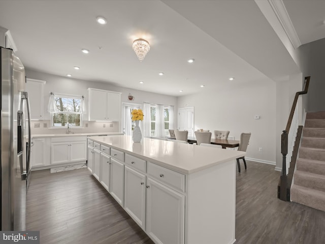 kitchen featuring white cabinets, a center island, dark hardwood / wood-style floors, and stainless steel fridge