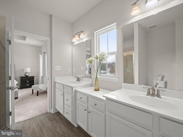 bathroom featuring hardwood / wood-style flooring, an enclosed shower, and vanity