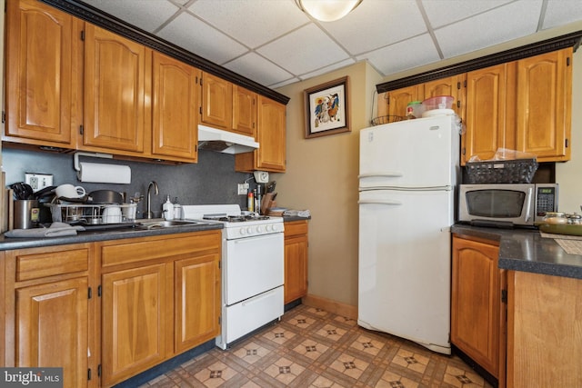 kitchen with sink, white appliances, and a drop ceiling