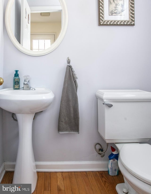 bathroom featuring wood-type flooring and toilet