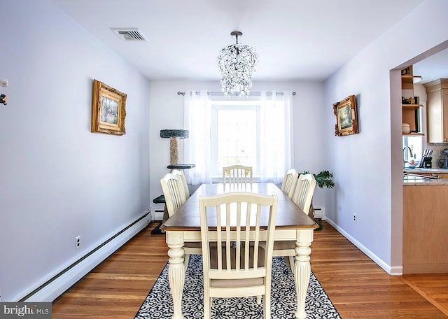 dining area with a baseboard radiator, dark hardwood / wood-style floors, and a notable chandelier