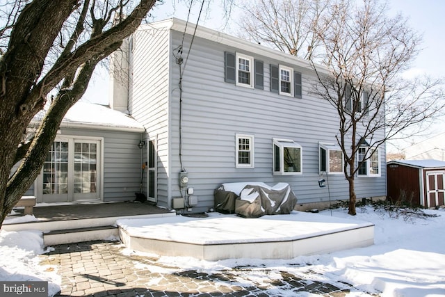 snow covered property with a shed