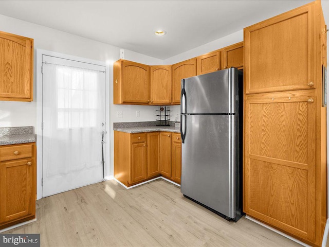 kitchen featuring light wood-type flooring and stainless steel refrigerator