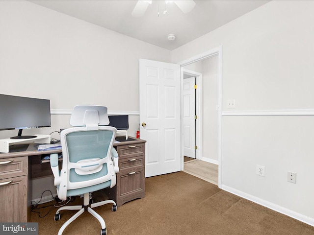 carpeted home office featuring ceiling fan