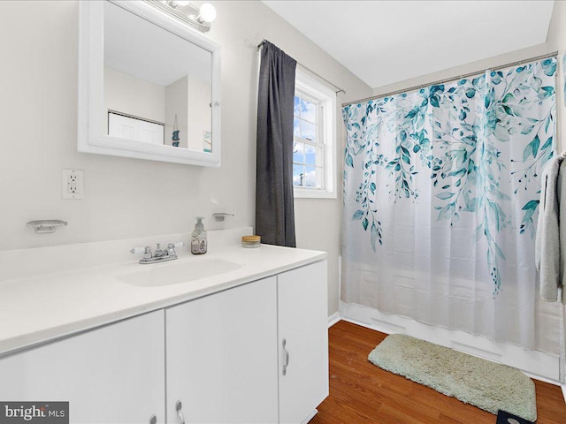 bathroom with hardwood / wood-style flooring, walk in shower, and vanity