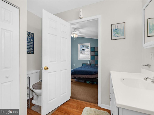 bathroom with vaulted ceiling, ceiling fan, hardwood / wood-style floors, toilet, and vanity