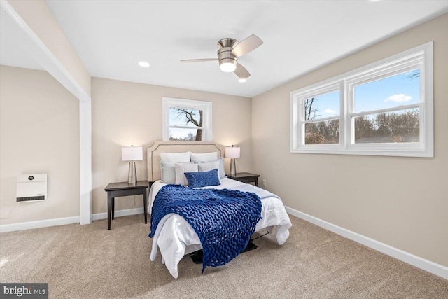 carpeted bedroom with multiple windows and ceiling fan