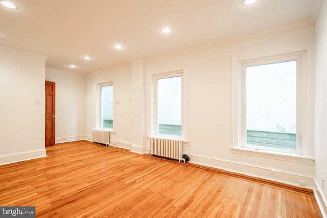 unfurnished room with ornamental molding, radiator heating unit, and light hardwood / wood-style floors