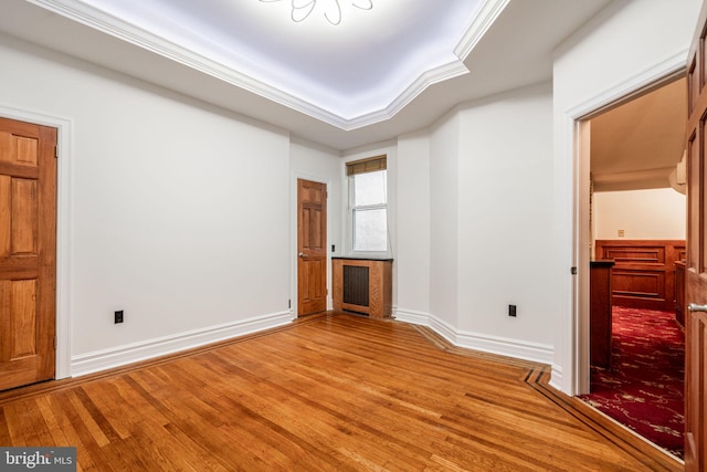 unfurnished bedroom featuring wood-type flooring and crown molding