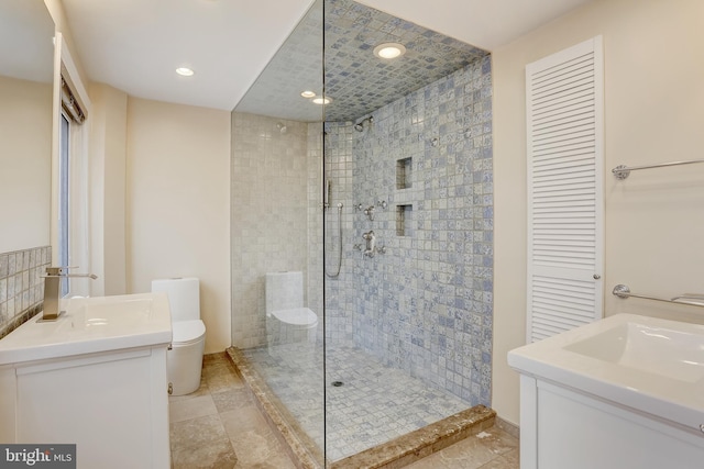 bathroom featuring vanity, toilet, and tiled shower