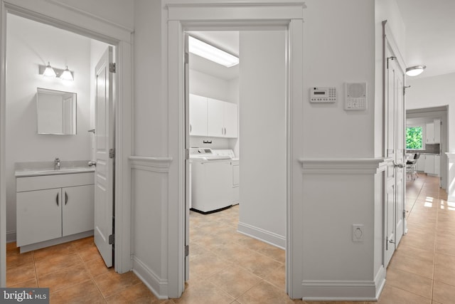 bathroom with washing machine and dryer, tile patterned floors, and sink