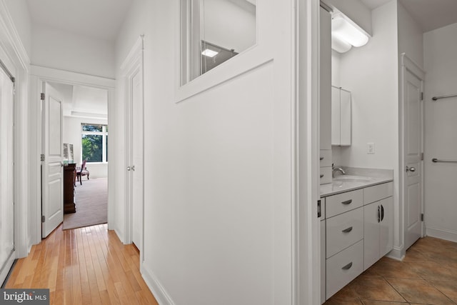 hall featuring sink and light wood-type flooring