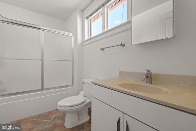 full bathroom featuring toilet, enclosed tub / shower combo, tile patterned flooring, and vanity