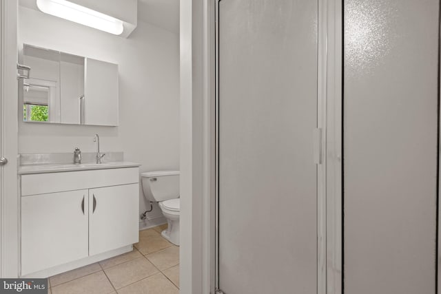 bathroom featuring toilet, tile patterned floors, vanity, and an enclosed shower