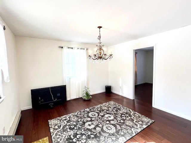 dining room featuring a notable chandelier, dark hardwood / wood-style floors, and a baseboard heating unit