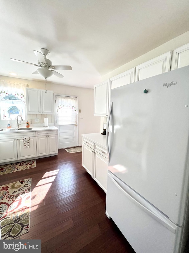 kitchen featuring sink, ceiling fan, dark hardwood / wood-style floors, white cabinets, and white fridge