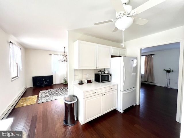 kitchen with tasteful backsplash, a baseboard heating unit, white cabinets, and white fridge