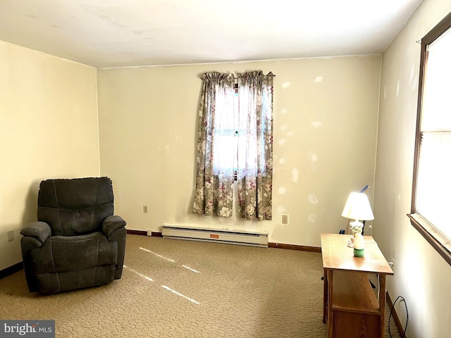 sitting room featuring a baseboard heating unit and carpet floors