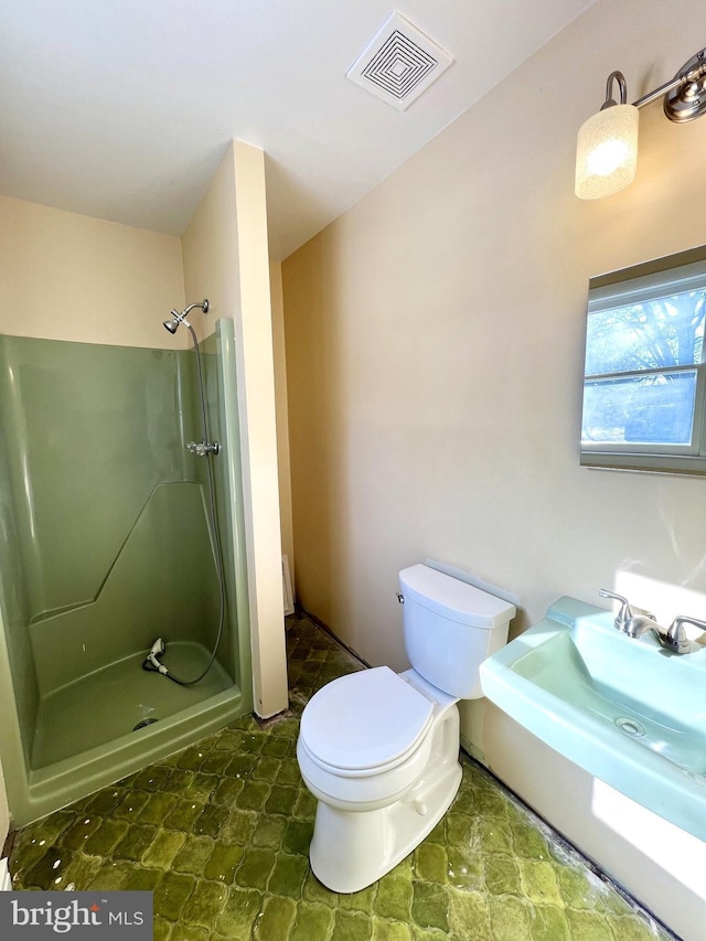 bathroom with toilet and a shower