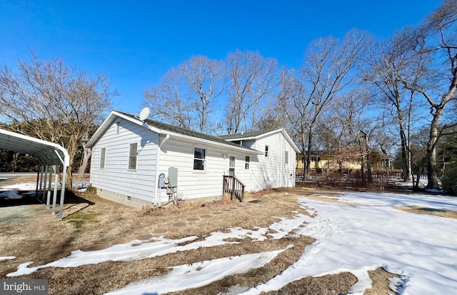 snow covered property featuring a carport