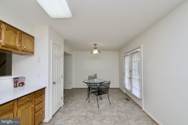 dining space featuring visible vents, baseboards, and stone finish floor