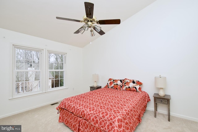 carpeted bedroom featuring visible vents, lofted ceiling, baseboards, and a ceiling fan