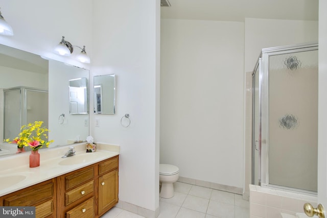 bathroom featuring tile patterned floors, double vanity, a shower stall, and a sink