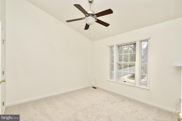 empty room featuring a ceiling fan, baseboards, visible vents, lofted ceiling, and light colored carpet