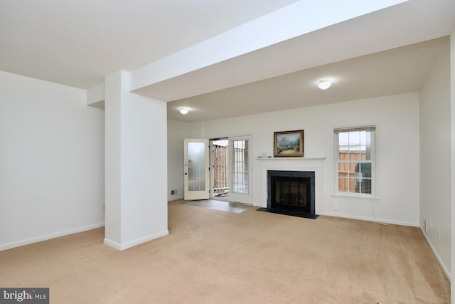 unfurnished living room with a fireplace with flush hearth, light colored carpet, and baseboards