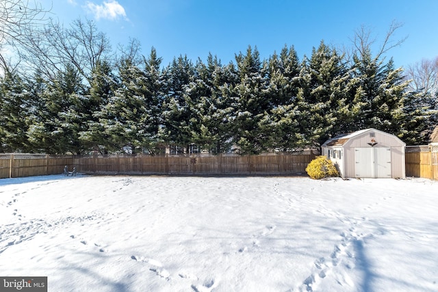 snowy yard featuring a shed